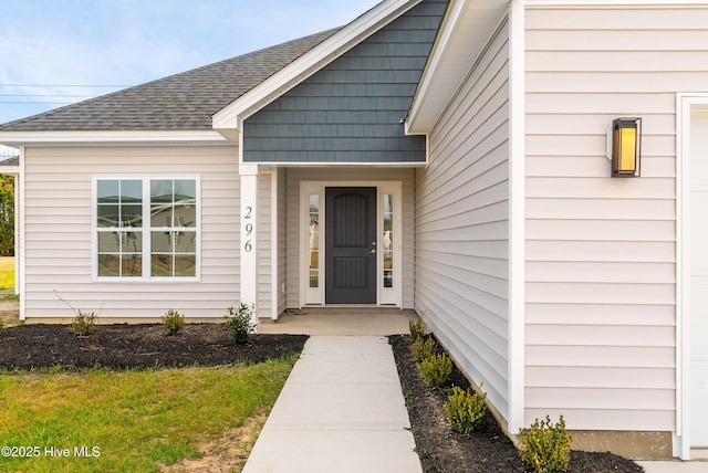 doorway to property with roof with shingles