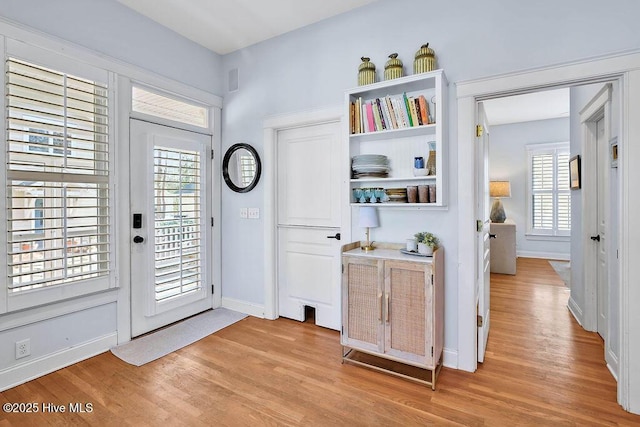 doorway featuring light wood-type flooring and baseboards