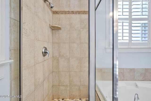 bathroom with a stall shower and a garden tub