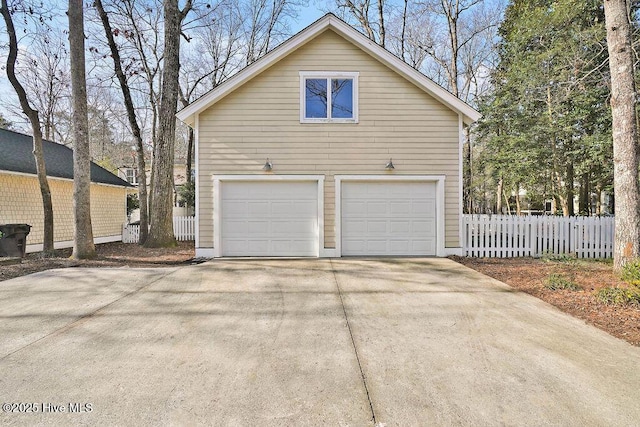 view of side of property featuring a garage and fence