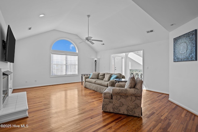 living area featuring a ceiling fan, visible vents, vaulted ceiling, and hardwood / wood-style floors