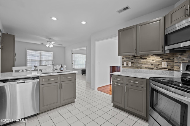 kitchen featuring stainless steel appliances, a sink, visible vents, and gray cabinetry