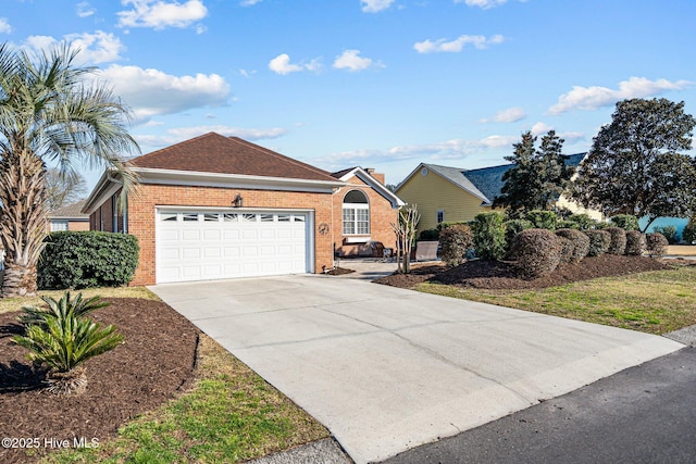 ranch-style house with a garage, a shingled roof, concrete driveway, and brick siding