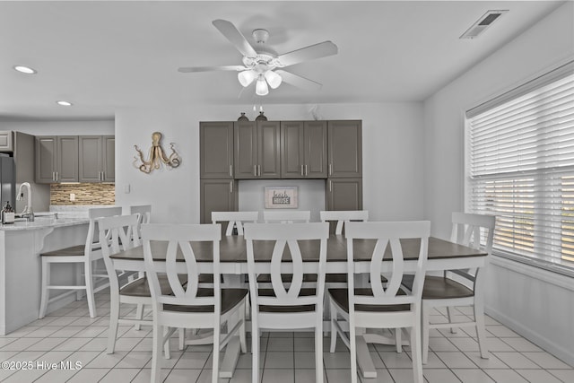 dining space featuring light tile patterned floors, baseboards, visible vents, and a ceiling fan