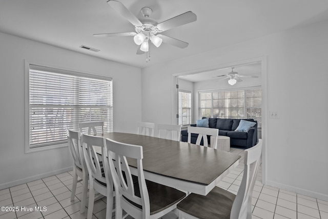 dining room featuring baseboards, visible vents, ceiling fan, and light tile patterned flooring