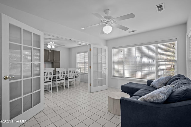 living area featuring a ceiling fan, french doors, visible vents, and light tile patterned floors