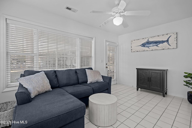 living room with light tile patterned floors, visible vents, and a ceiling fan