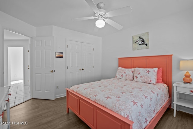 bedroom featuring dark wood-style floors, a ceiling fan, and a closet