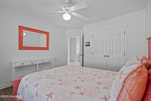 bedroom featuring dark wood-type flooring, a closet, a ceiling fan, and baseboards