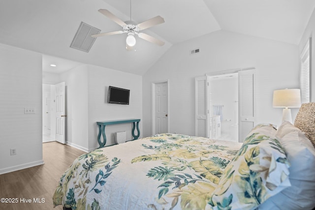 bedroom with lofted ceiling, visible vents, baseboards, and wood finished floors