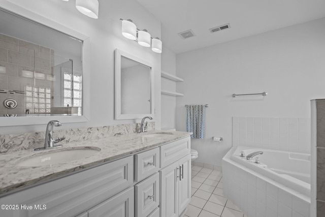 bathroom featuring toilet, visible vents, a sink, and tile patterned floors