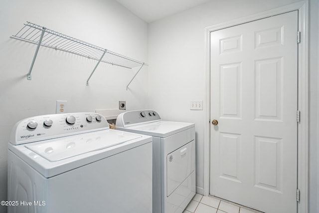 laundry room featuring light tile patterned floors, laundry area, and washing machine and dryer