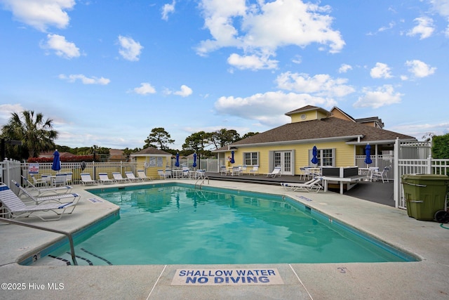 community pool featuring fence, french doors, and a patio