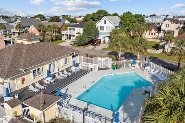 pool with a residential view, fence, and a patio