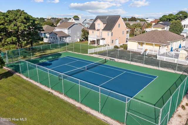 view of sport court featuring a yard, fence, and a residential view