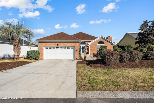 ranch-style home with brick siding, a shingled roof, concrete driveway, an attached garage, and a front lawn