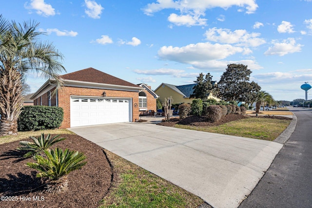 single story home featuring a garage, driveway, and brick siding