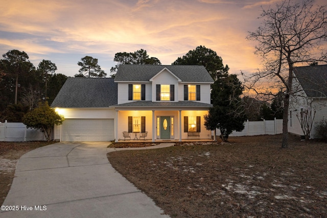 traditional home featuring a porch, a garage, fence, concrete driveway, and roof with shingles