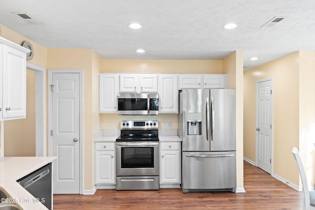 kitchen with stainless steel appliances, light countertops, visible vents, and white cabinetry