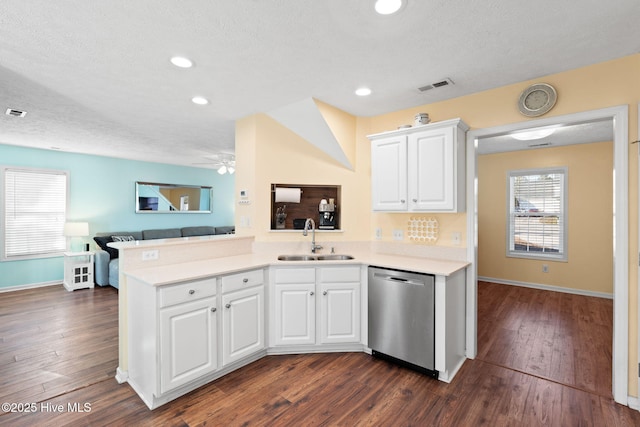 kitchen with visible vents, dark wood finished floors, open floor plan, stainless steel dishwasher, and a sink