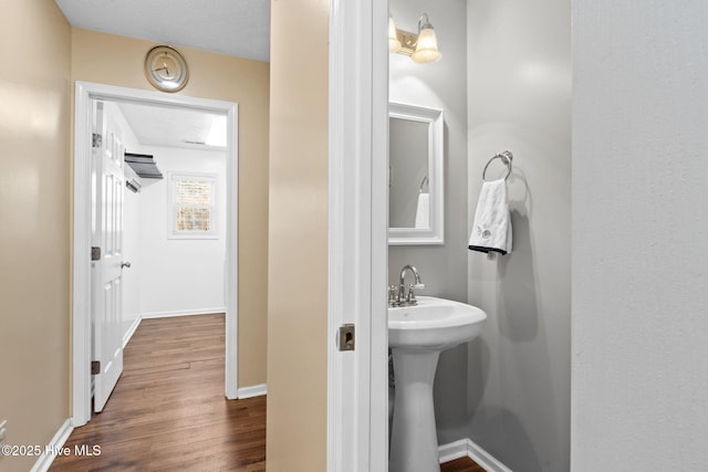 bathroom featuring a sink, baseboards, and wood finished floors