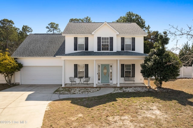 traditional-style home featuring driveway, a shingled roof, a porch, an attached garage, and a front lawn