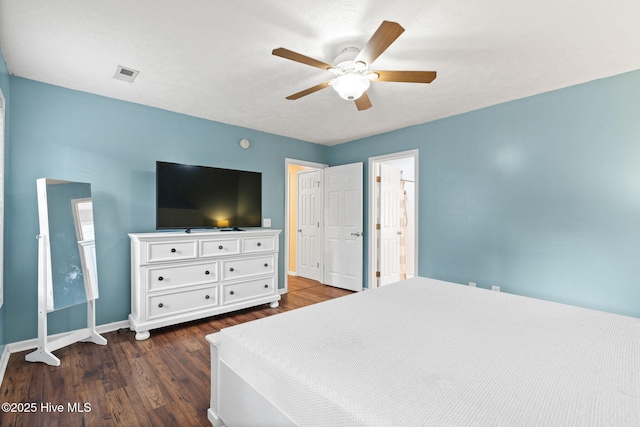 bedroom with baseboards, visible vents, dark wood finished floors, and a ceiling fan