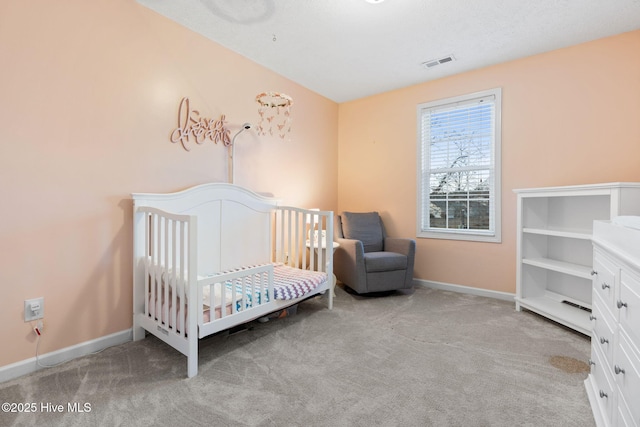 bedroom featuring carpet flooring, visible vents, baseboards, and a crib