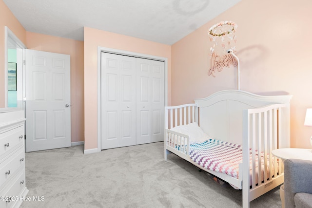 bedroom with light carpet, a closet, and baseboards