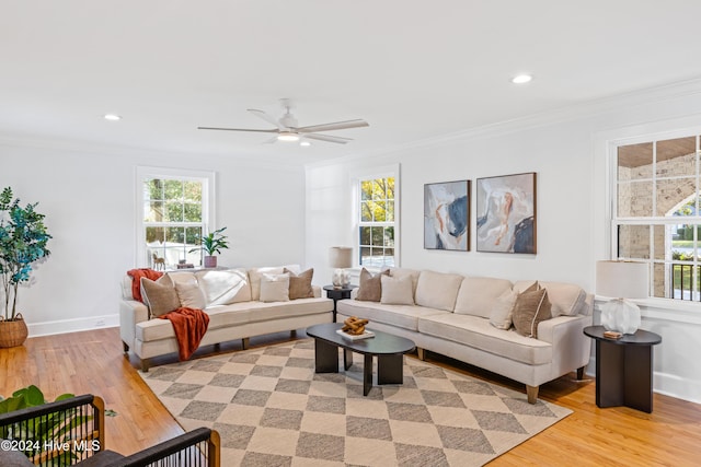 living room featuring recessed lighting, baseboards, crown molding, and light wood finished floors