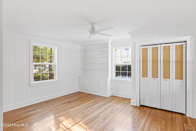 unfurnished bedroom with a closet, visible vents, ornamental molding, a ceiling fan, and light wood-type flooring