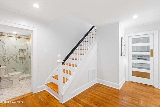 stairs featuring recessed lighting, wood finished floors, visible vents, baseboards, and crown molding