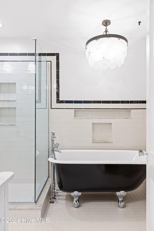 bathroom with a freestanding bath, a shower stall, and tile walls