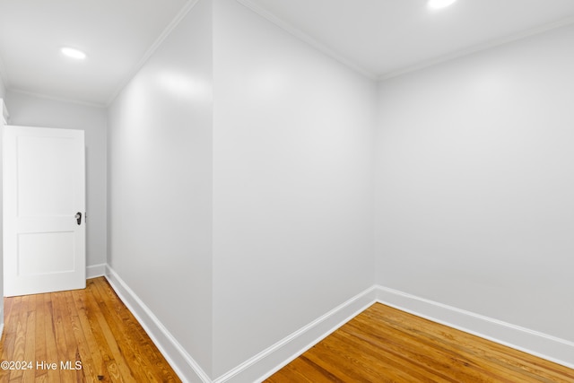 hall featuring ornamental molding, light wood finished floors, recessed lighting, and baseboards