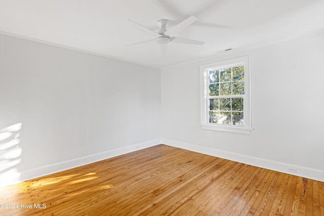 unfurnished room featuring light wood-style floors, visible vents, baseboards, and a ceiling fan