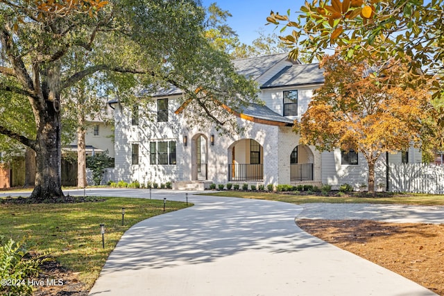 view of front facade featuring driveway, a front lawn, and brick siding