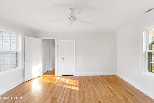 empty room featuring baseboards, ceiling fan, light wood-type flooring, and crown molding