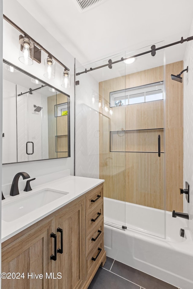 bathroom with visible vents, combined bath / shower with glass door, tile patterned flooring, and vanity