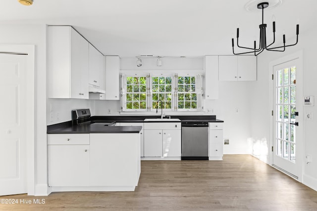 kitchen with stainless steel appliances, dark countertops, a healthy amount of sunlight, white cabinetry, and a sink