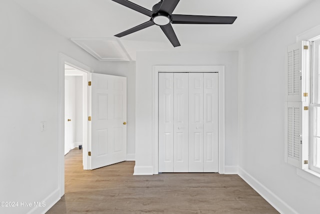 unfurnished bedroom featuring a ceiling fan, a closet, baseboards, and wood finished floors