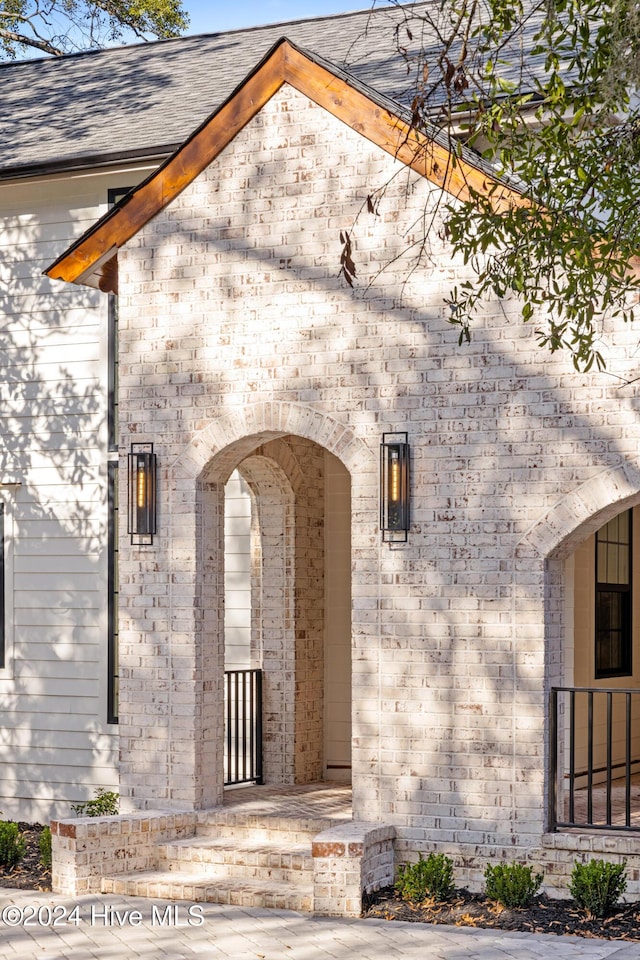 doorway to property featuring a shingled roof