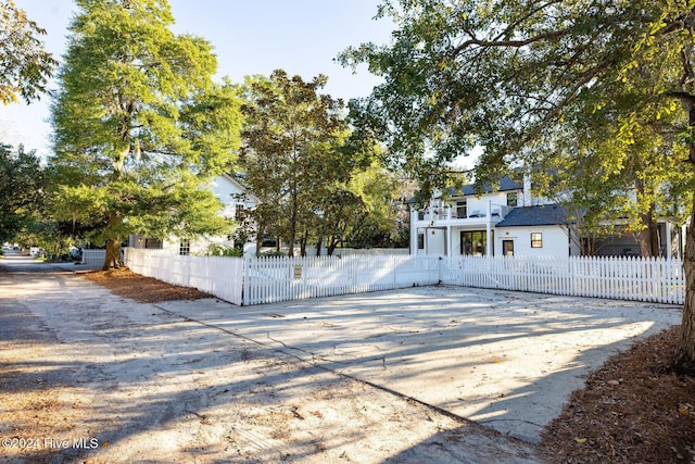 view of front facade with a balcony, a fenced front yard, and a gate