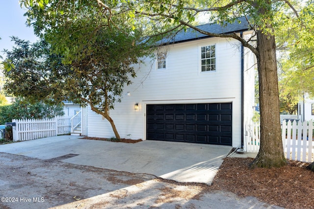 view of front of property with a garage, fence, and concrete driveway