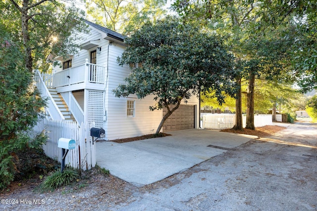 view of side of home featuring stairs and fence