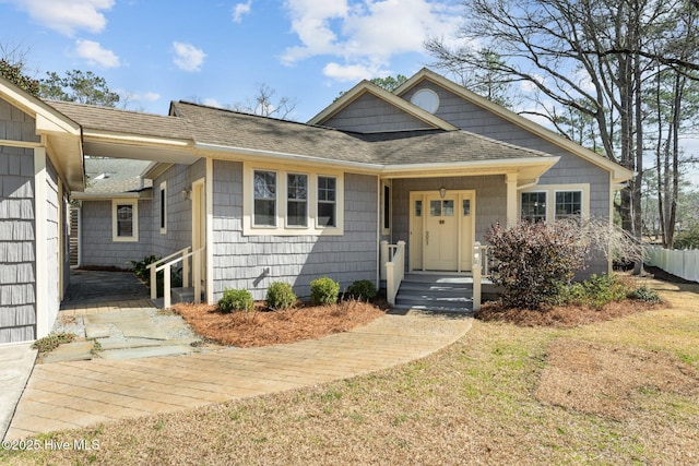 view of front of home with fence and roof with shingles