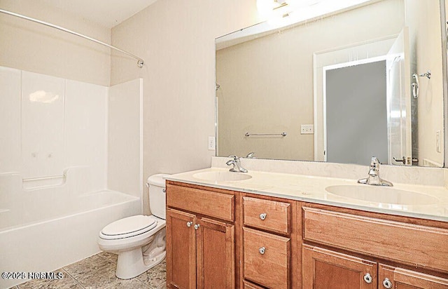 bathroom featuring toilet, double vanity, shower / washtub combination, and a sink