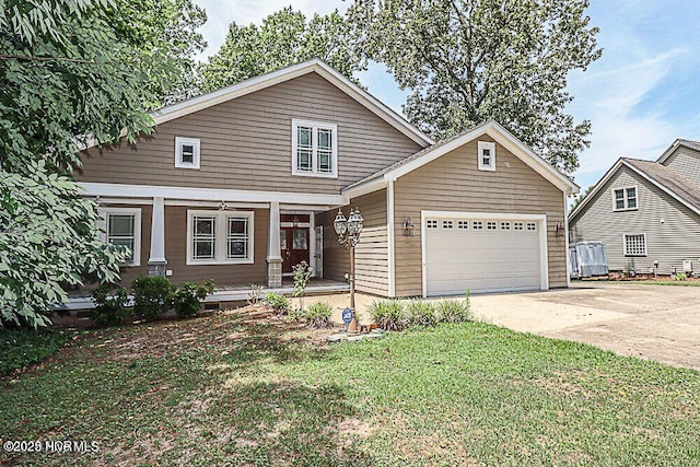 view of front of home featuring a garage, a front yard, covered porch, and driveway