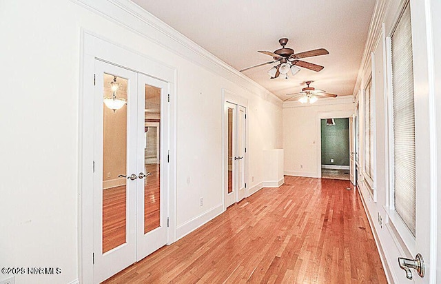 unfurnished room with a ceiling fan, baseboards, light wood-style floors, french doors, and crown molding