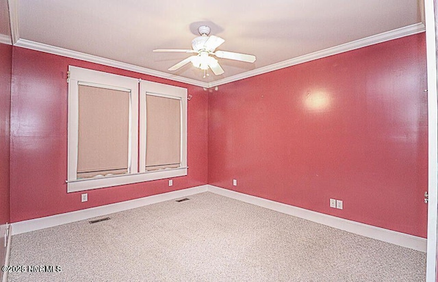 carpeted spare room featuring ceiling fan, ornamental molding, visible vents, and baseboards