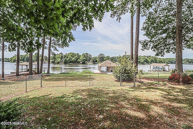 view of yard featuring a water view, fence, and a gazebo